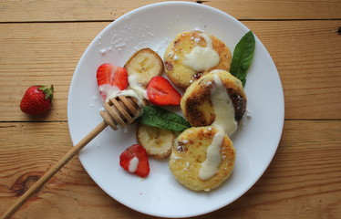 strawberry and cream. Cottage cheese pancakes cottage cheese with strawberry, mint, and banana. Ukrainian traditional food. Ukrainian national kitchen.