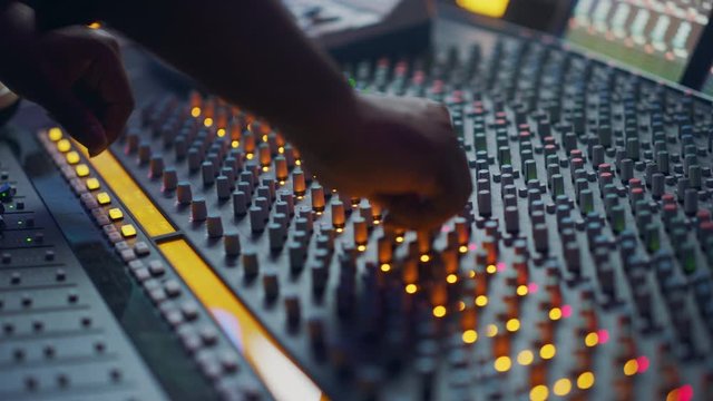 Audio Engineer, Music Creator, Musician, Artist Works in the Music Record Studio, Uses Surface Control Desk EQ Mixer. Buttons, Faders, Sliders to Broadcast, Record, Play Hit Song. Close-up Focus