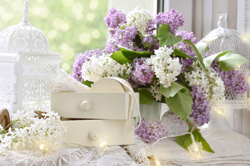 vintage style decoration with bunch of lilac blossoms on window sill
