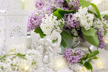 love decor with angels and bunch of lilac blossoms on window sill