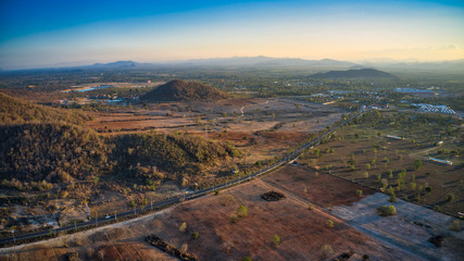 This unique photo shows the back landscape of Hua Hin in Thailand at sunset with a great sky. in the foreground the country road! The hills and mountain range in the background!