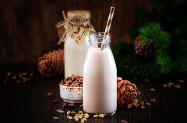 Vegan Cedar nut milk in bottles, closeup, wooden table background. Non dairy alternative milk. Healthy vegetarian food and drink concept. Copy space