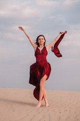 Obraz premium Girl in red dress at sunset in the desert