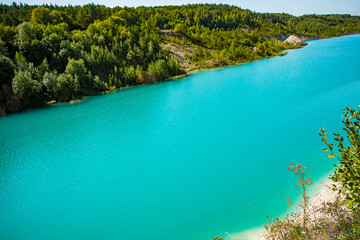 Beautiful landscape - a mountain lake with unusual turquoise water. Stone coast with green trees.