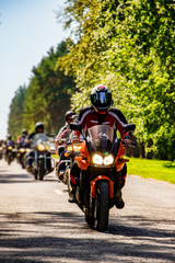 Motorcyclist rides on the road on a summer day.