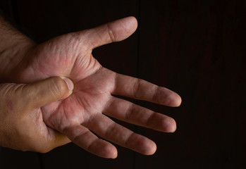 Adult man with pain in his hands. Automassage of hands to relieve pain.