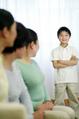 Boy standing with his arms folded, the rest watching