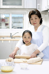Senior woman and girl baking in the kitchen