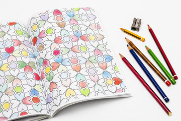 Hearts design in coloring book with colored pencils. Valentine Day
