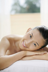 Fototapeta premium Woman lying forward on massage table, smiling
