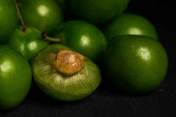 Close-up macro fresh green sour plum. Greengage on dark background.  