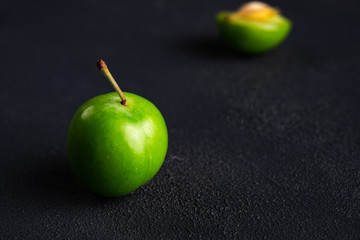 Close-up macro fresh green sour plum. Greengage on dark background.  
