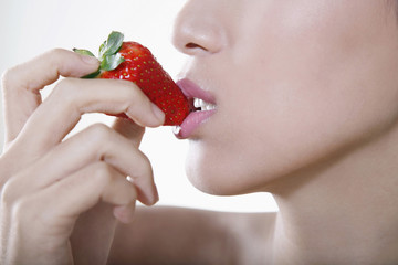 Close-up of woman eating strawberry