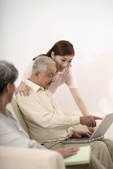 Obraz na płótnie Canvas Senior man pointing at laptop while woman looks on
