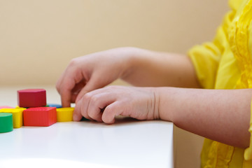 the child plays with colored figures. Details of the toy in the hands. Concept of development of fine motor skills, educational games, childhood, IVF, children's day, kindergarten. copy space