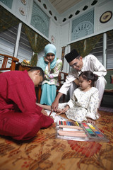 Boy and girl colouring their books, man and woman watching