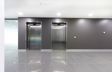 Two lifts or elevators in a building lobby.