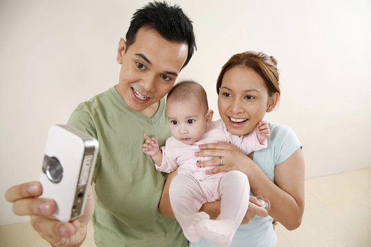 Man and woman taking picture with baby