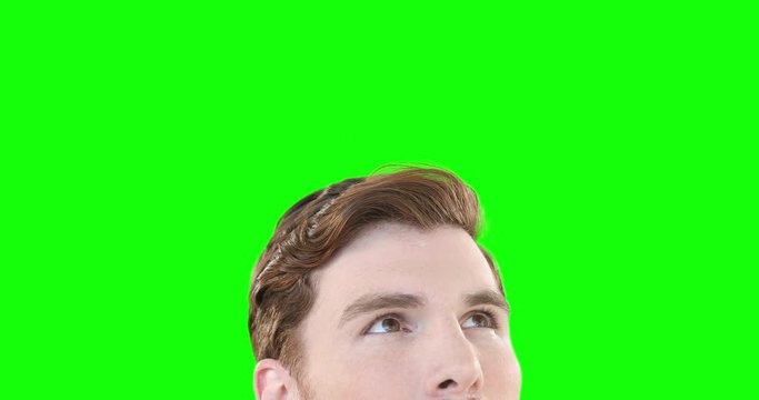 Caucasian man looking up on green background