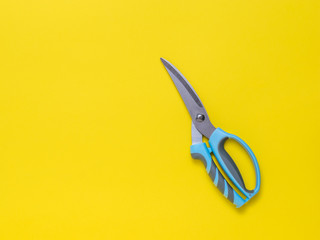 Kitchen scissors on a yellow background. Flat lay.