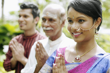 Couple and senior man praying
