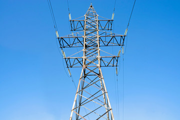 Pylon of an overhead power line (transmission pylon) against a blue sky