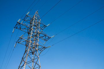 Pylon of an overhead power line (transmission pylon) against a blue sky