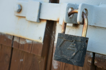 old padlock hanging on an old fence closeup