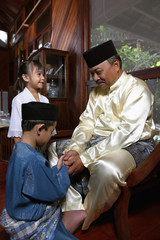 Boy greeting senior man, girl watching at the side