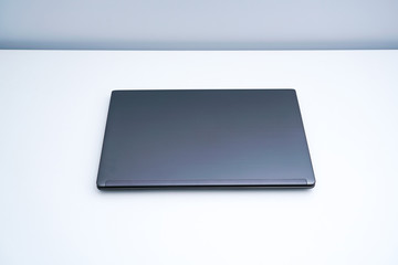 A dark gray laptop on a white desk