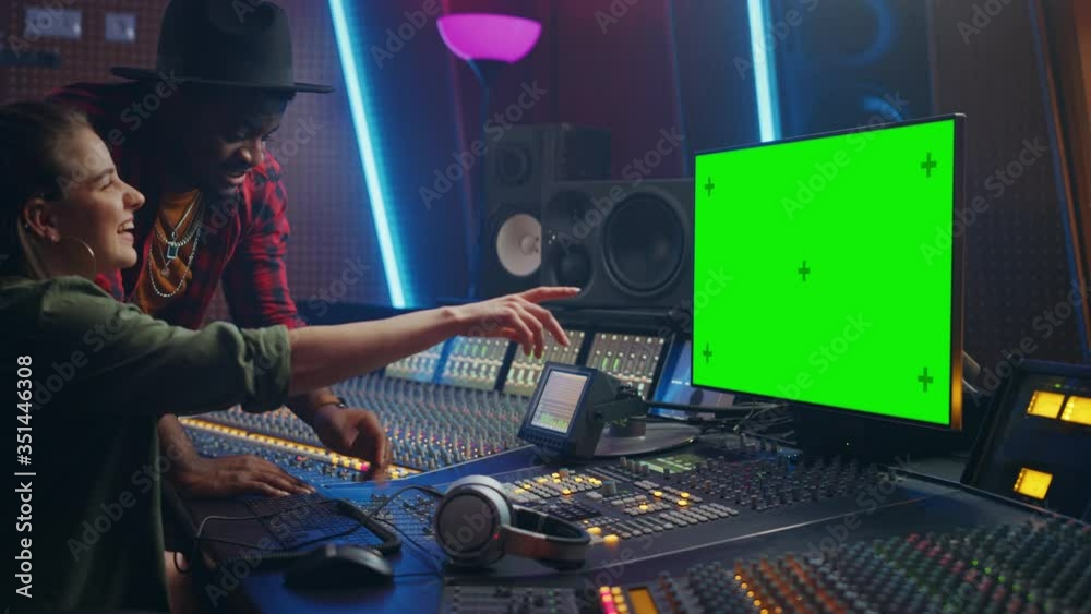Poster producer and audio engineer working together in music record studio on a new album, use green screen