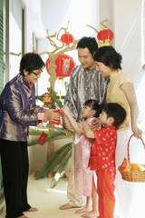 Couple with their children visiting senior woman