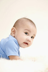 Baby lying forward on fur