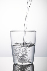 Macro shot of water pouring into a glass