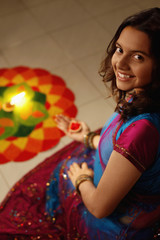 Teenage girl drawing kolam on the floor