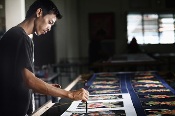 Man painting batik fabric