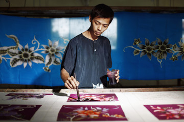 Man painting batik fabric