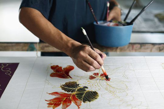 Man painting batik fabric