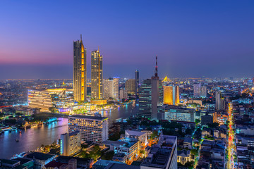 Naklejka premium View of Bangkok cityscape. Aerial view of business modern building around the Chao Phraya river in Thailand at twilight time.