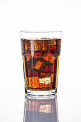 Cold carbonated drink over ice cubes in a  glass