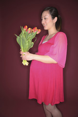 Pregnant woman holding a bouquet of flowers