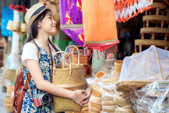 Asian girl, travel and shopping in traditional basketry shop
