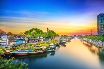Flower boats full of flowers parked along canal wharf in sunset, a place for bustling flower market...