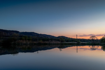 Fototapeta na wymiar Lake with a reflective surface at sunset