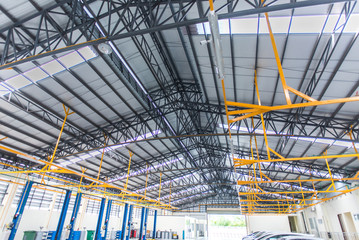 The interior decoration is an epoxy floor of an industrial building or a large automobile repair center with a steel roof structure that is built in an industrial factory.