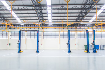 The electric lift for cars in the service put on the epoxy floor in new car factory service , Car repair service center blurred background for industry