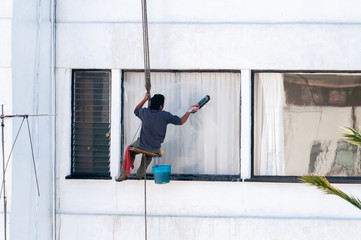 Trabajador limpia ventana exterior en edificio de Ciudad de México con pocas medidas de seguridad