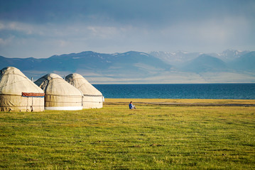 Reading a book at the side of Yurts at Song Kul Lake during sunset, Kyrgyzstan - 351463334