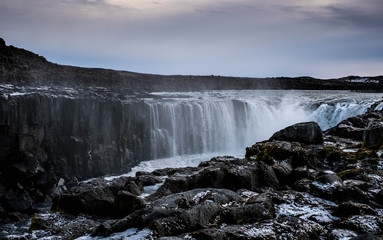 Selfoss waterfall in Northeast Iceland runs through a rock gorge through the autumn snow