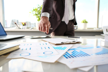 Male arm point finger at important paper on table